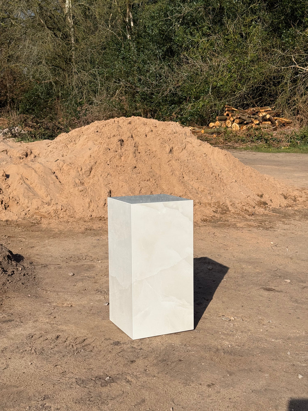 Side view of white marble-effect polished porcelain side table showing mitred corner detail
